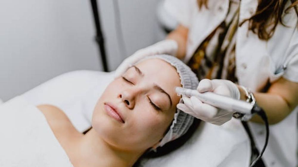 Client receiving a professional facial treatment at an aesthetics clinic